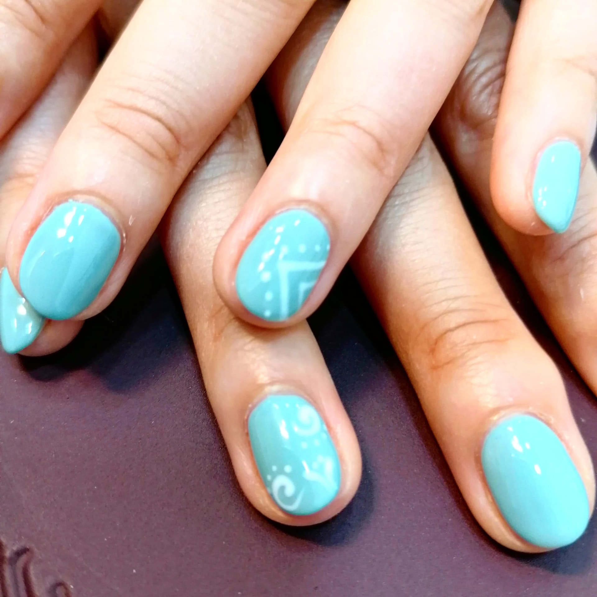 Manicure em azul-claro com detalhes brancos