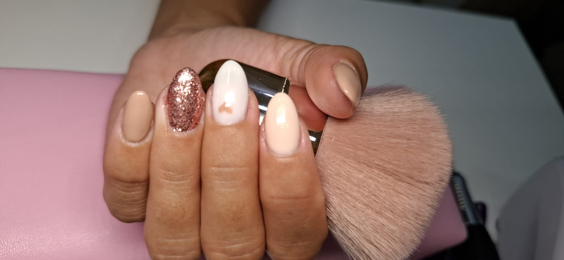 Manicure nude e branca com brilho rosa e detalhe de coração