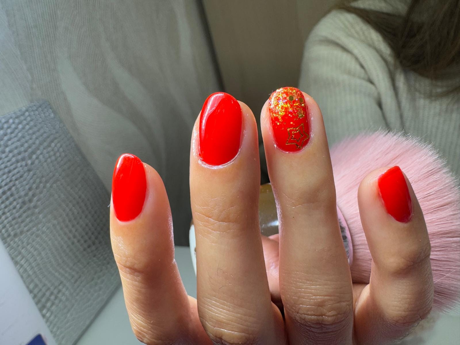 Manicure vermelha com glitter dourado e estrela festiva
