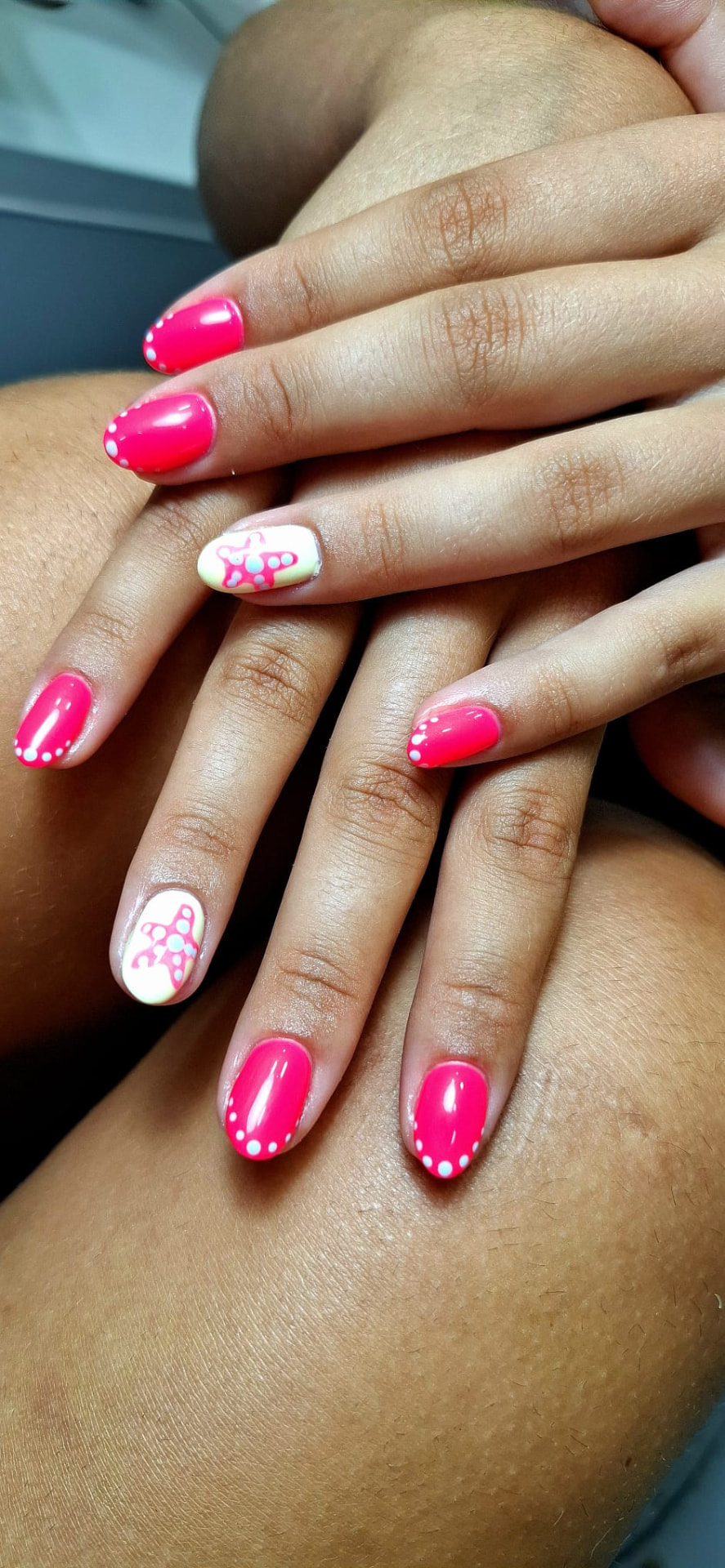 Manicure rosa vibrante com estrela-do-mar e pontos brancos