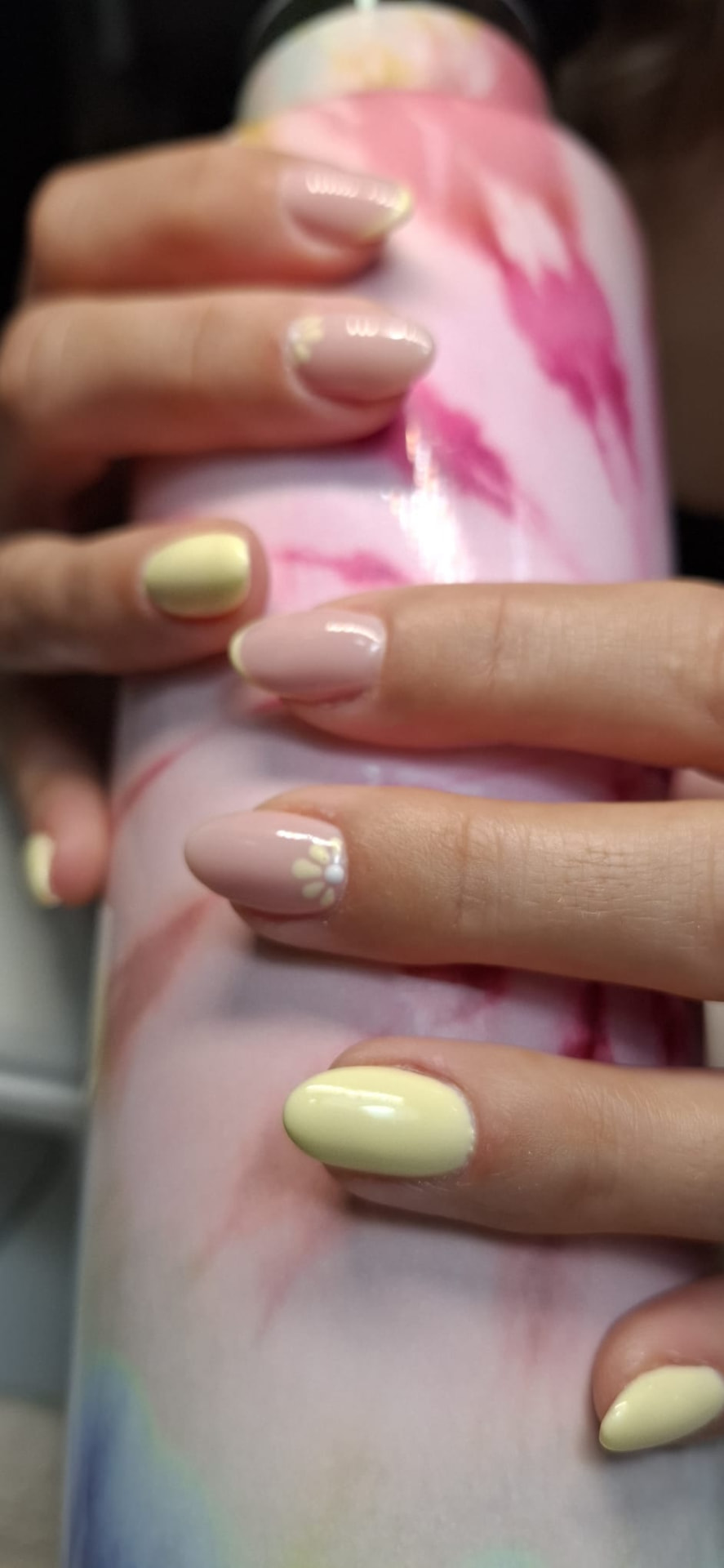Manicure amarelo pastel e rosa nude com flores brancas