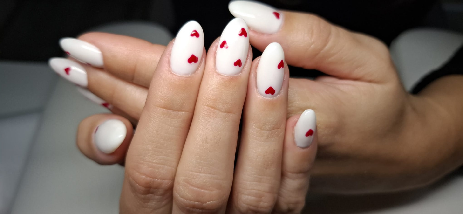 Manicure branca com pequenos corações vermelhos