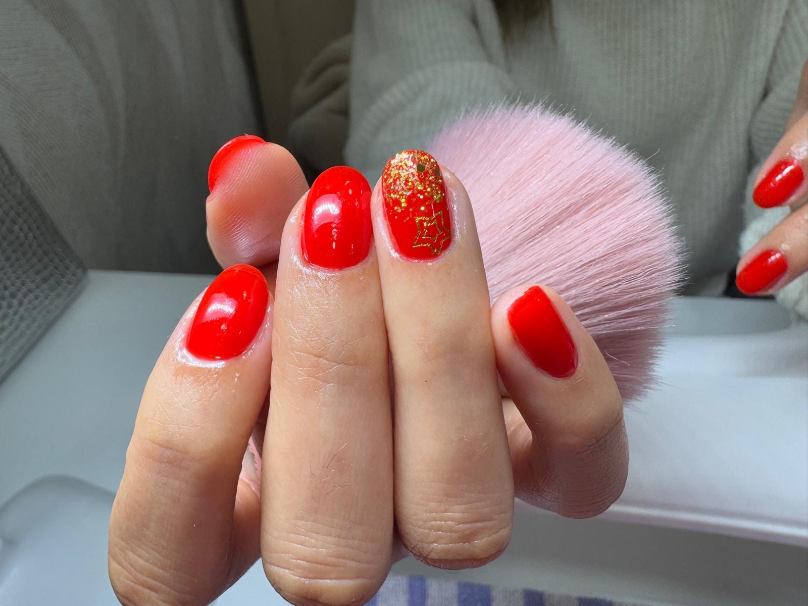 Manicure vermelha com estrela dourada e glitter