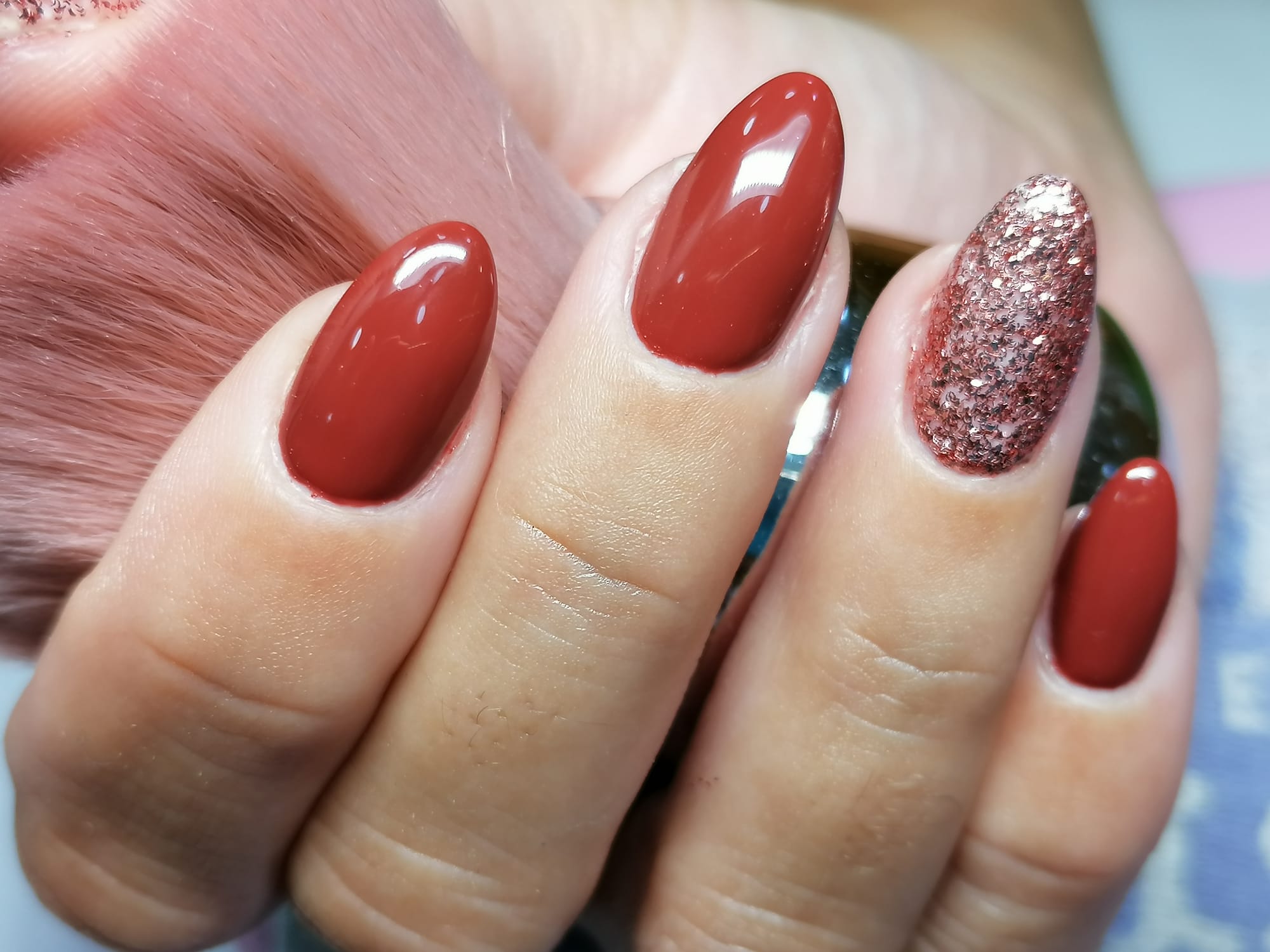 Manicure vermelha com unha de brilho rosa